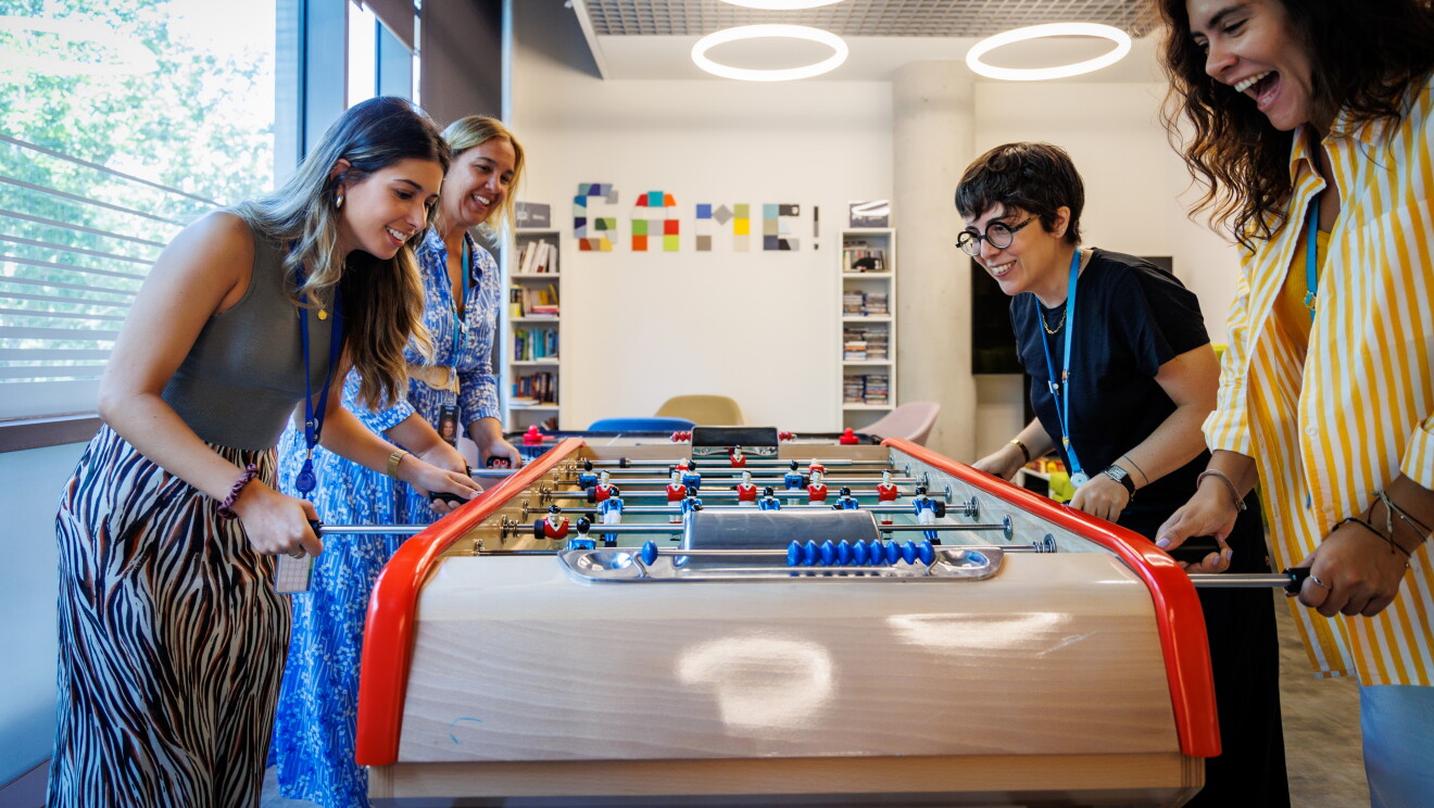 Cuatro trabajadoras de Aamzon jgadno a un futbolín. 