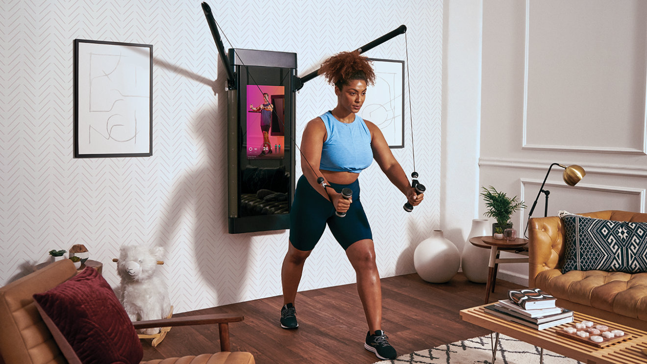 A woman exercises in her living room.