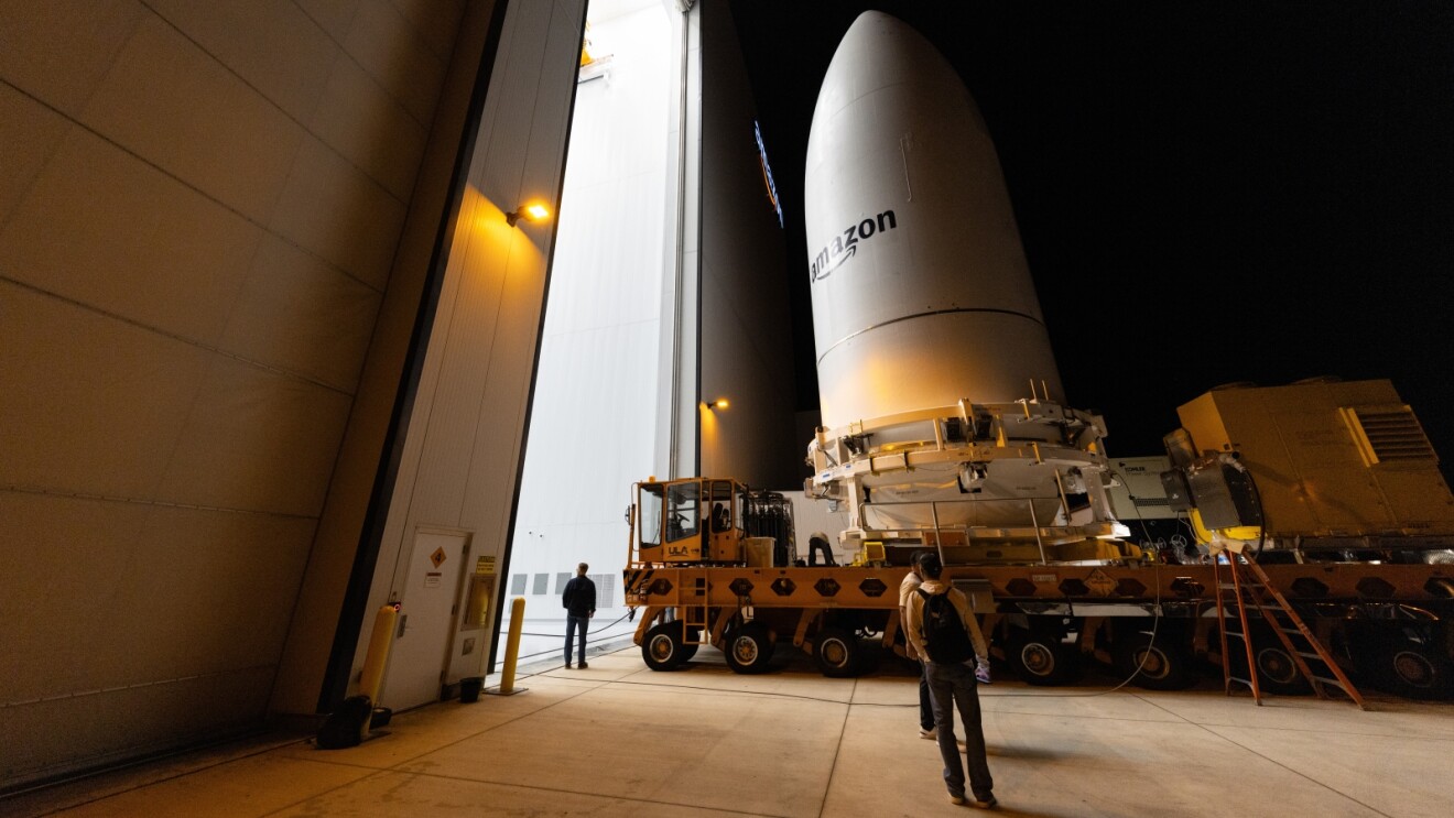 Spacecraft preparation with Amazon logo visible in launch facility at night