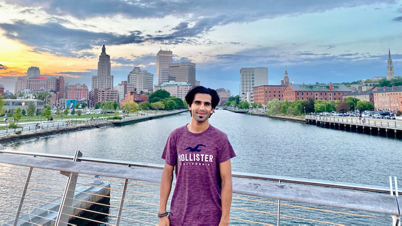 An image of Shahidullah Mohammadi with a city and a bay in the background. 