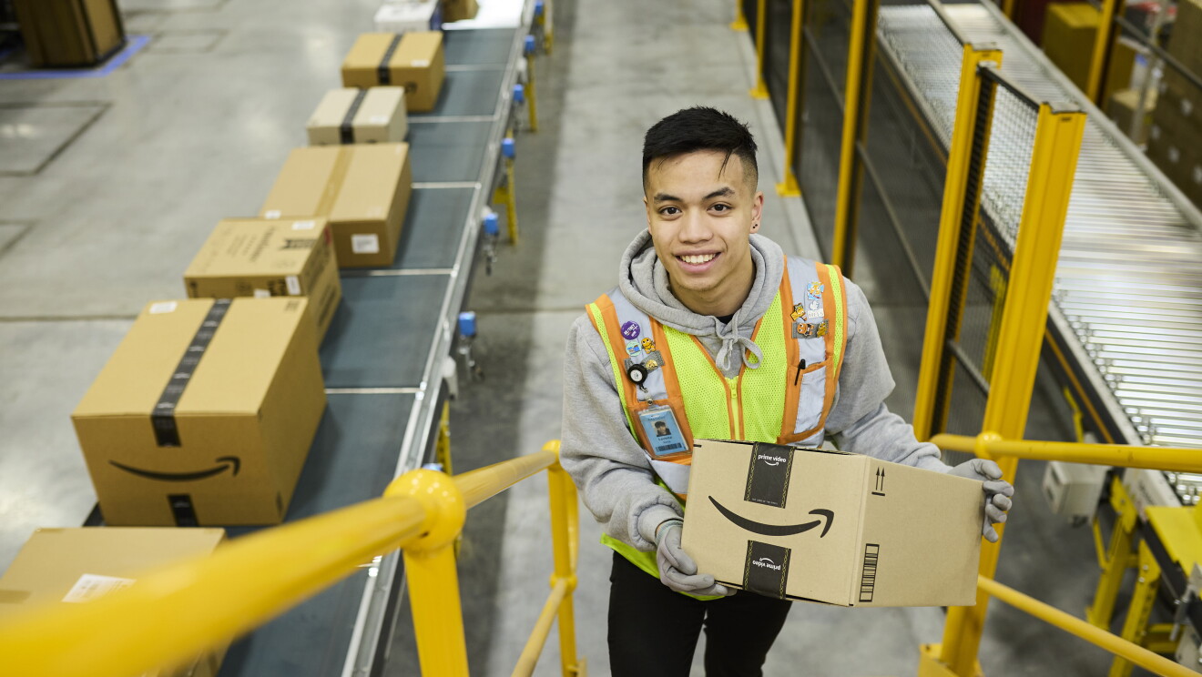 Amazon fulfilment centre team members smiling in high vis vests 