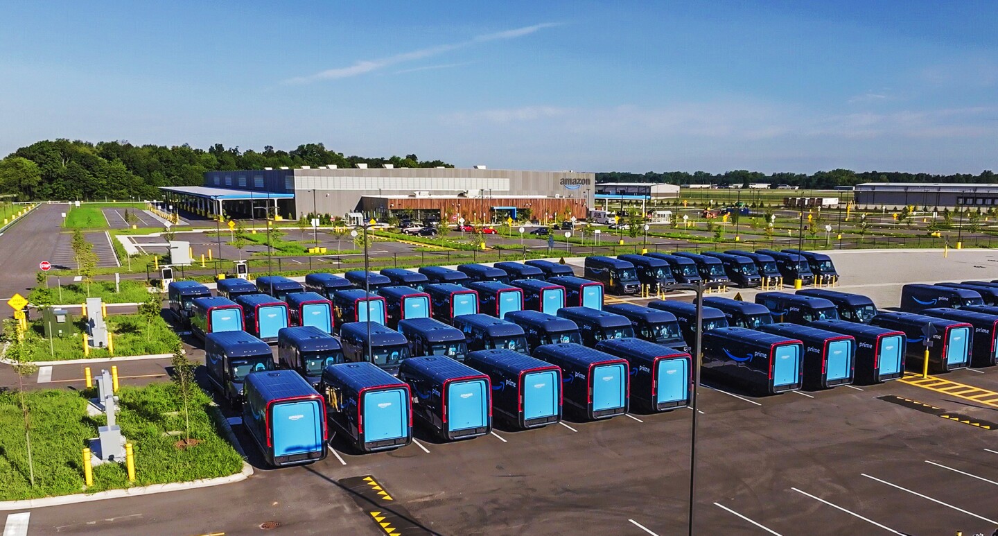 Fleet of Rivian electric delivery vans parked in rows at Amazon's sustainability-focused delivery station in Elkhart, Indiana