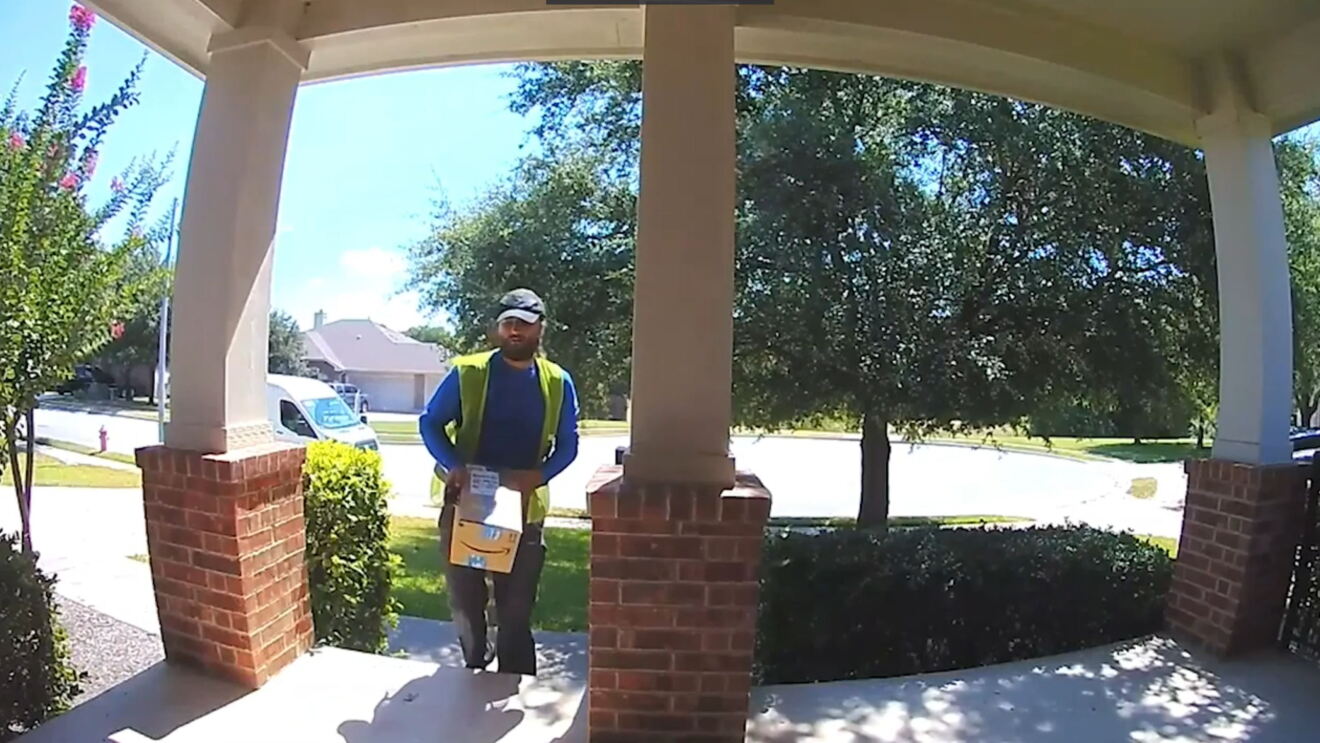 Deliver driver approaches the porch of a home. 
