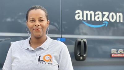 Amazon Delivery Service Partner Quanique Toston stands in front of an Amazon delivery van.
