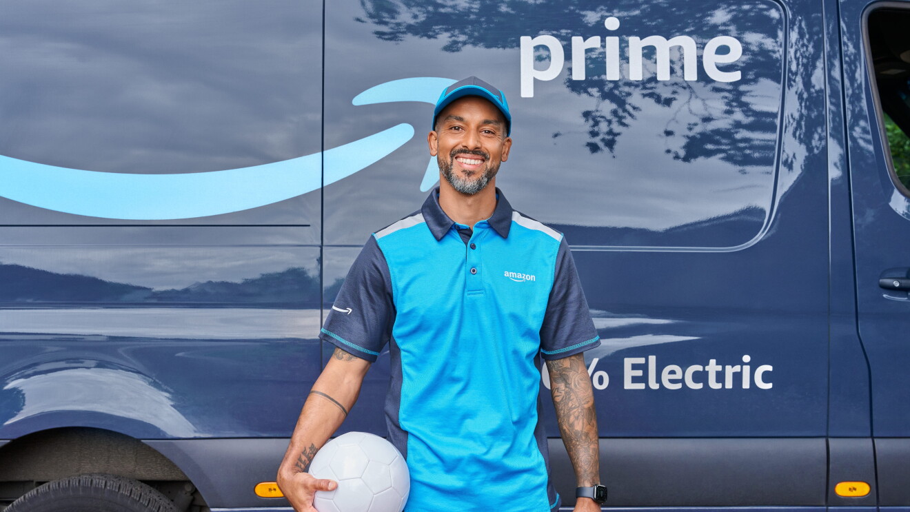 Theo Wool Walcott stands with a football in hand in front of an Amazon Prime van to deliver packages for Prime Day 2026