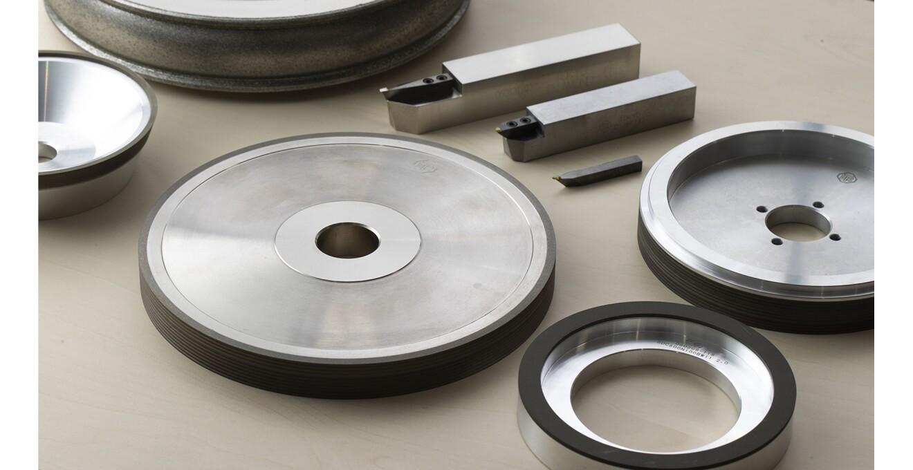 先端にダイヤモンドをつけた工具と、それによって縁に溝が作られた円盤型の金属工具たちがならぶ写真