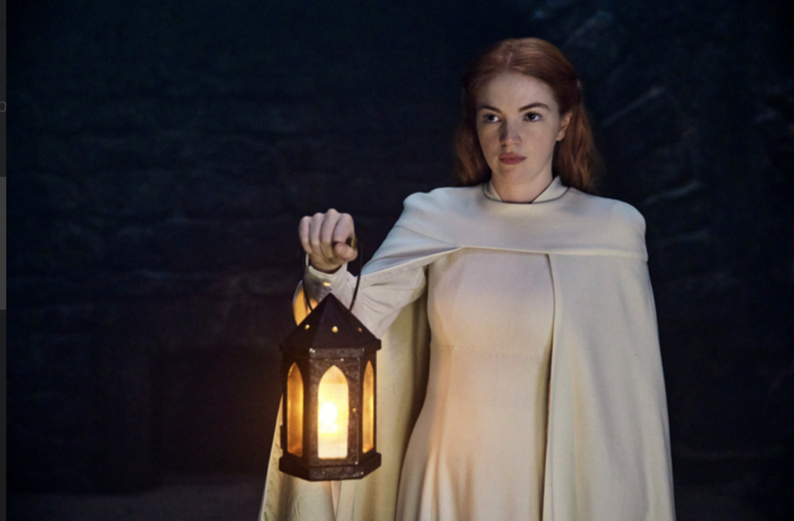 Elayne Trakand from The Wheel of Time holding a lantern in a dark room