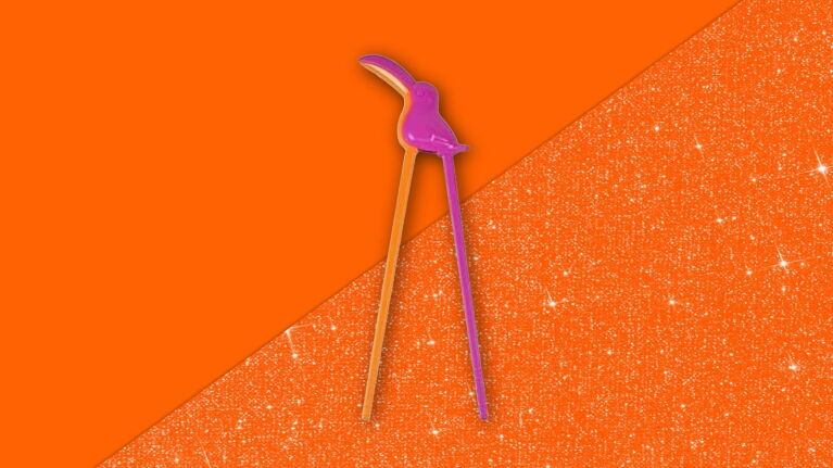 Purple flamingo-shaped chopsticks on vibrant orange glittery background
