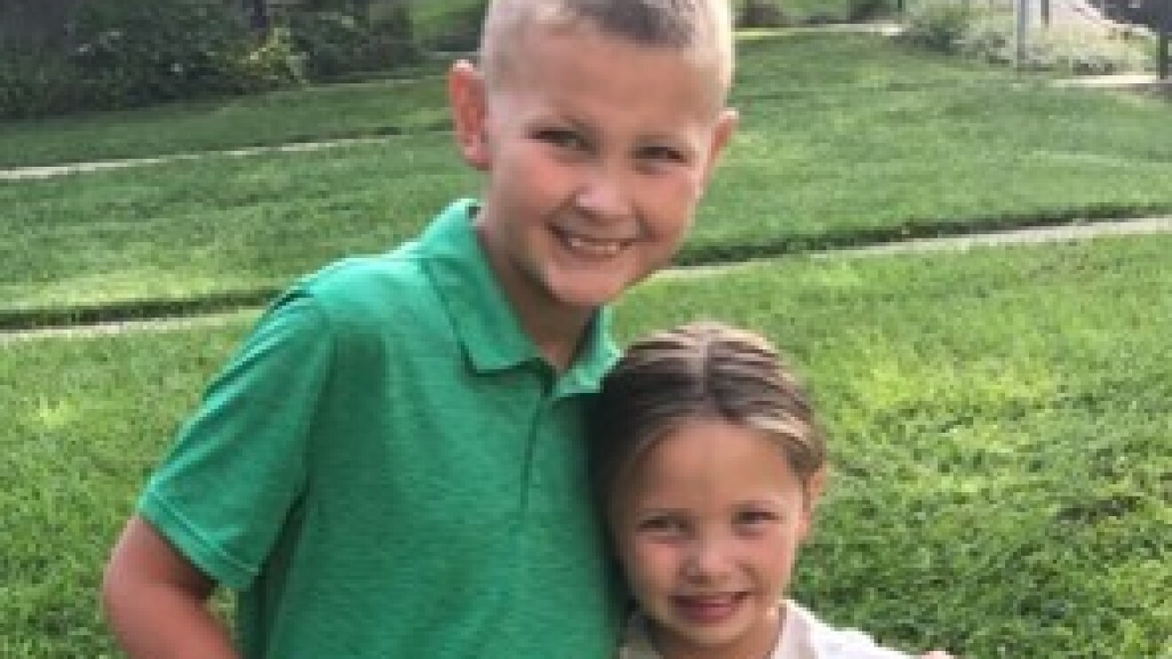 An image of two children smiling for a photo outside.