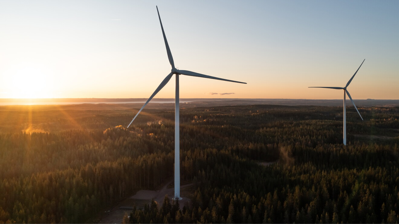 Wind turbines in a rural setting with the sun setting behind