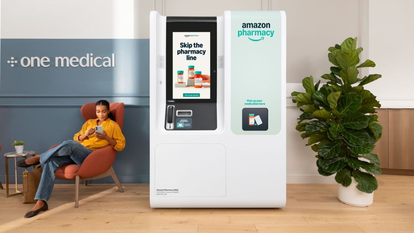 Self-service Amazon Pharmacy kiosk in medical office waiting area with person seated nearby