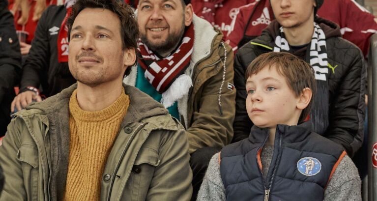 Vater und Sohn sitzen im Fußballstadion