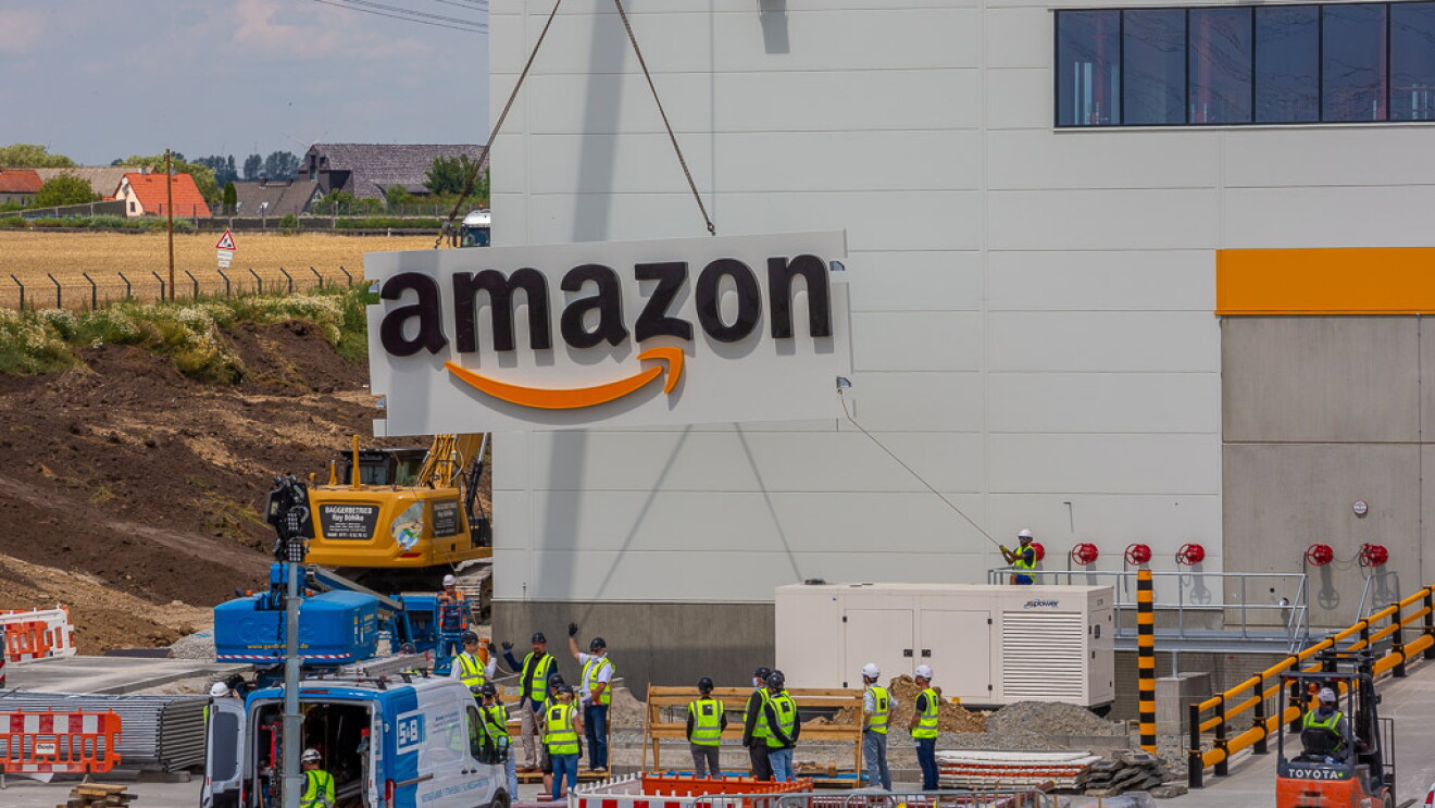 Das Amazon  Logo wird per Kran am Außengebäude angebracht.