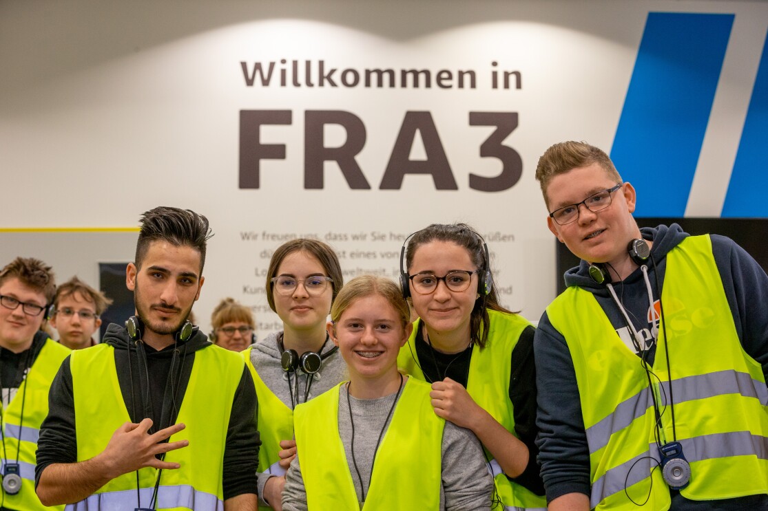Diverse Besucher in gelben Westen im Logistikzentrum