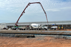 A photo of cement trucks pouring concrete outside of an AWS data center that is under construction.