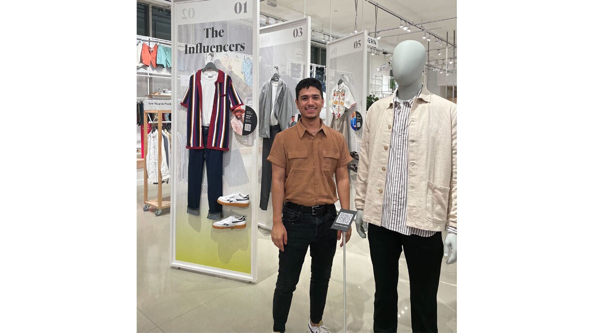 An image of a man standing next to a mannequin in an Amazon Style clothing store.