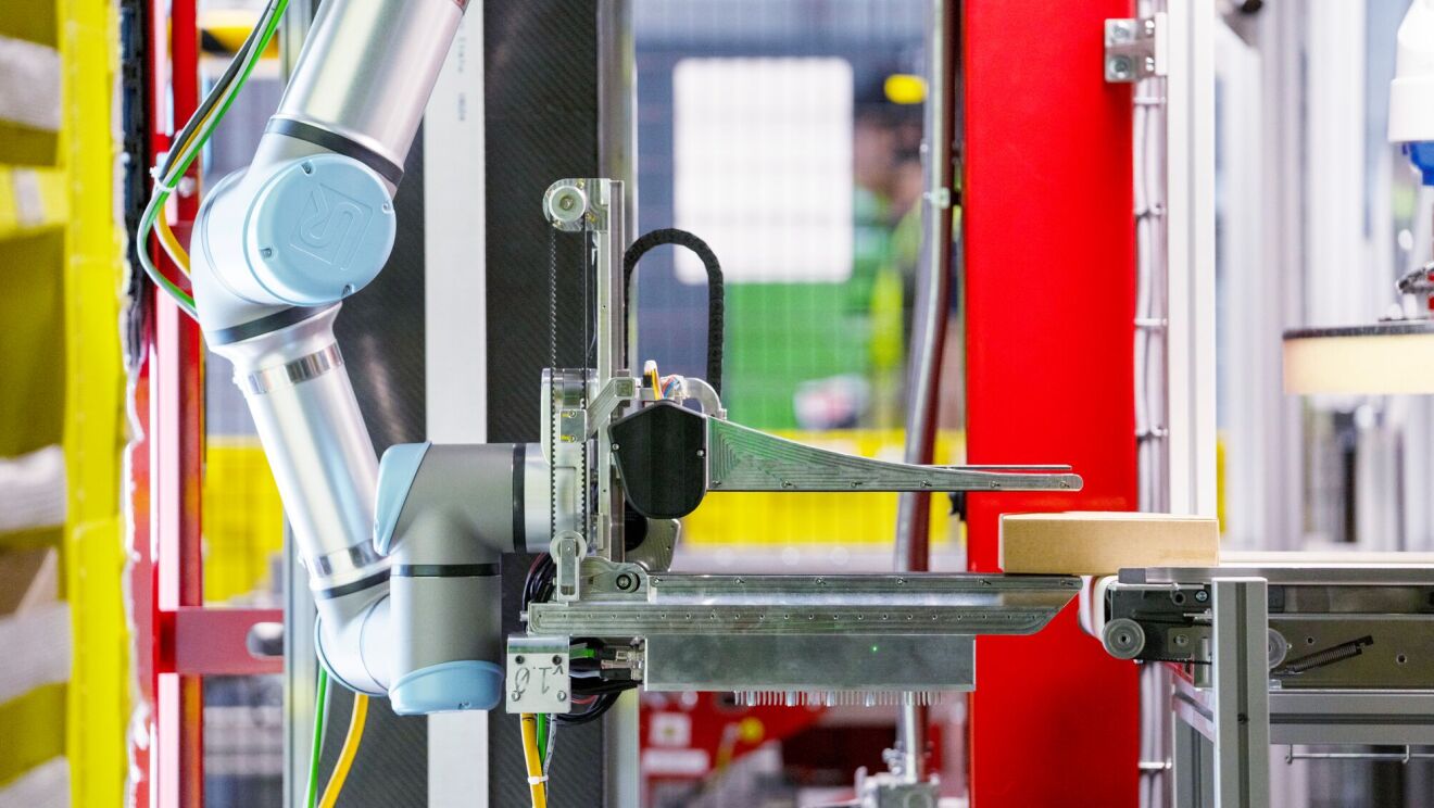 Amazon's new robot system, Vulcan, picking up a cardboard box.