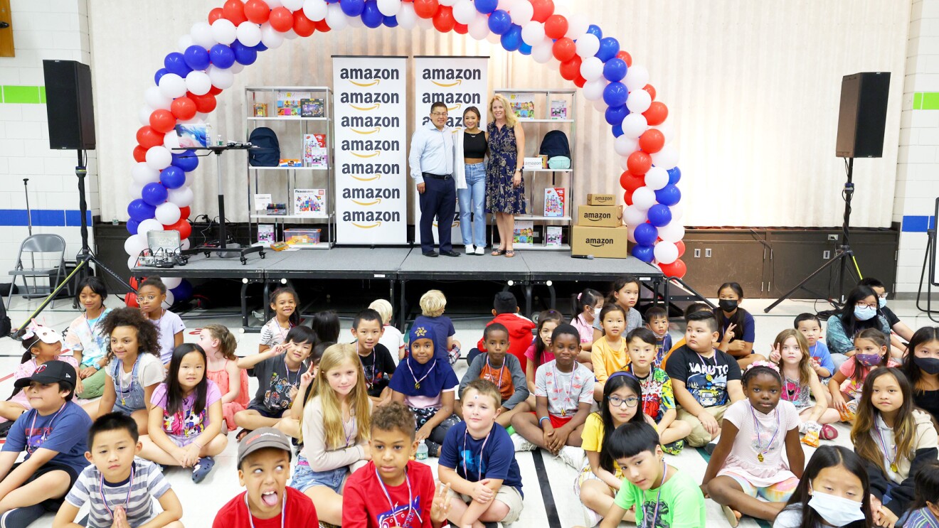 Suni Lee在一所小学与学生合影。