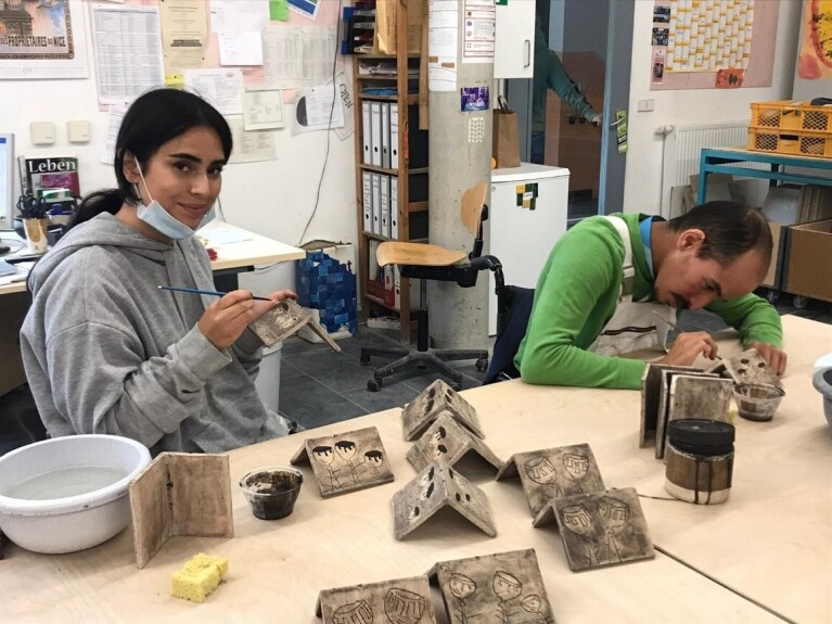 Mitarbeiter:innen von Amazon bei der Arbeit in einer Werkstatt für Menschen mit Beeinträchtigung.