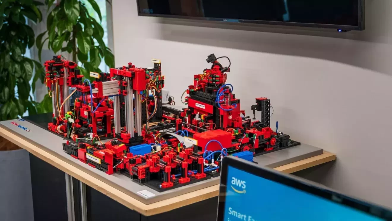 赤いレゴやコードなどから作られた複雑で立体的な回路が机の上に置かれている
