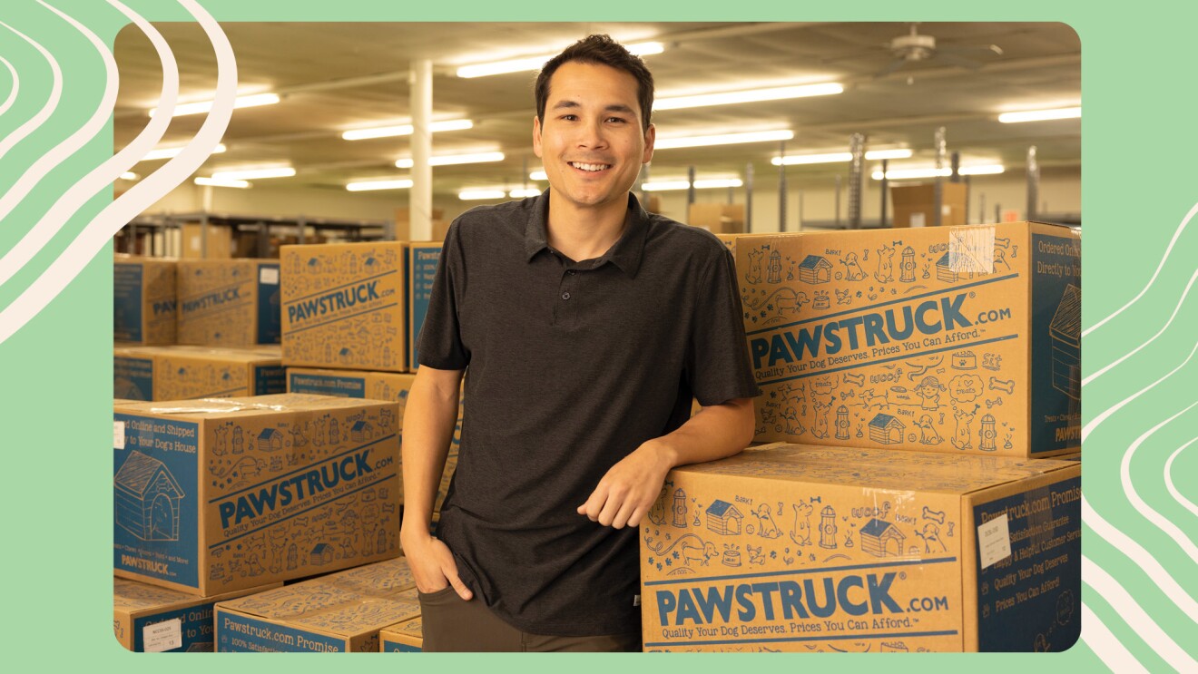 一位小企业主在亚马逊上销售,靠包Pawstruck狗待在他的仓库。