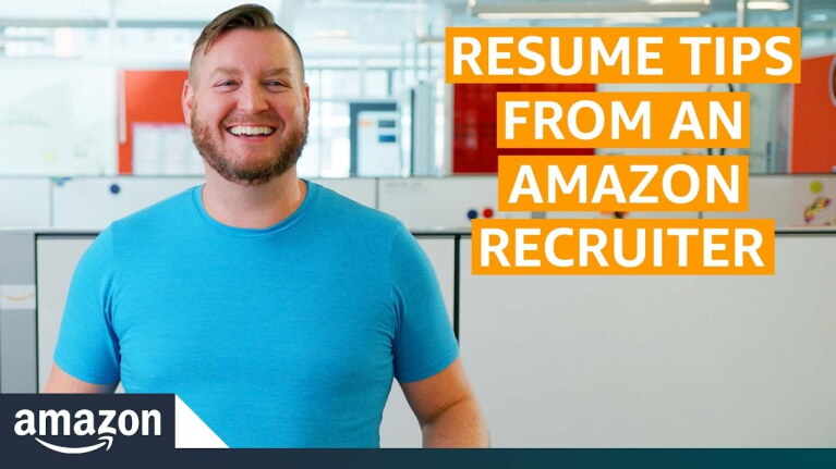 An image of a man smiling while looking off into the distance. The background behind him is an Amazon office.
