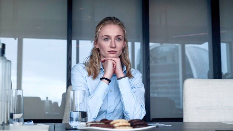 Pensive woman in light blue shirt at conference table