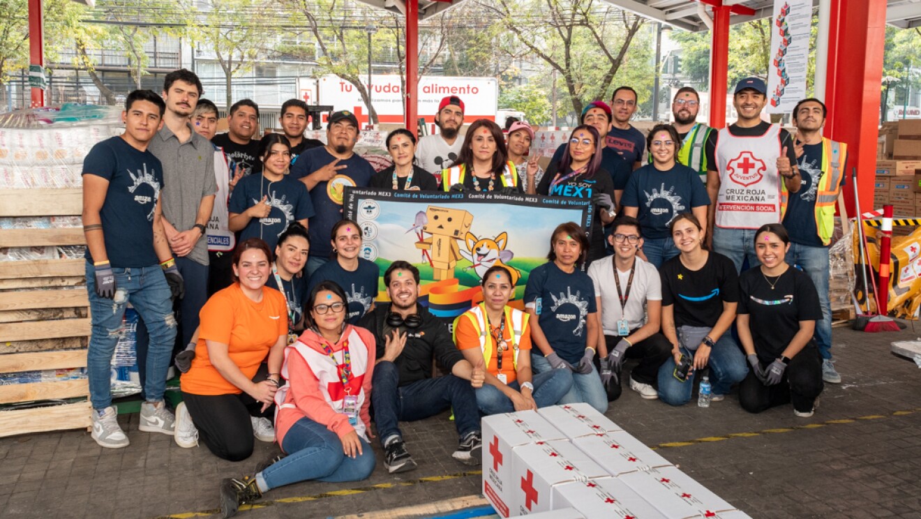 Voluntarios de Amazon delante de cajas de la Cruz Roja.
