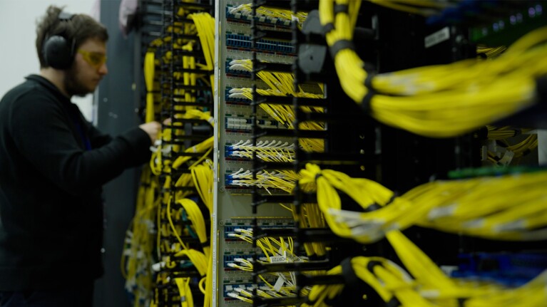 A photo of a technical working on a set of glass tubes in an AWS failure analysis lab.