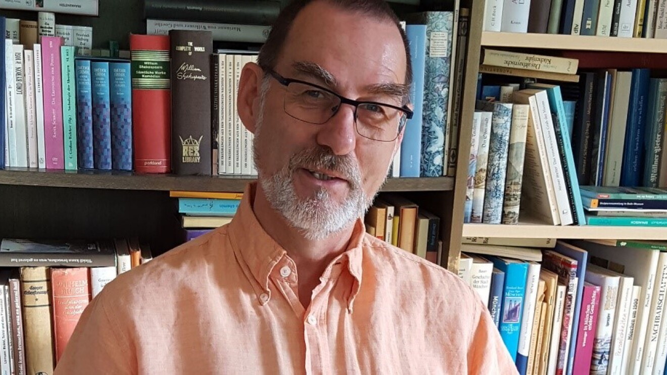 Mann vor Bücherregal
