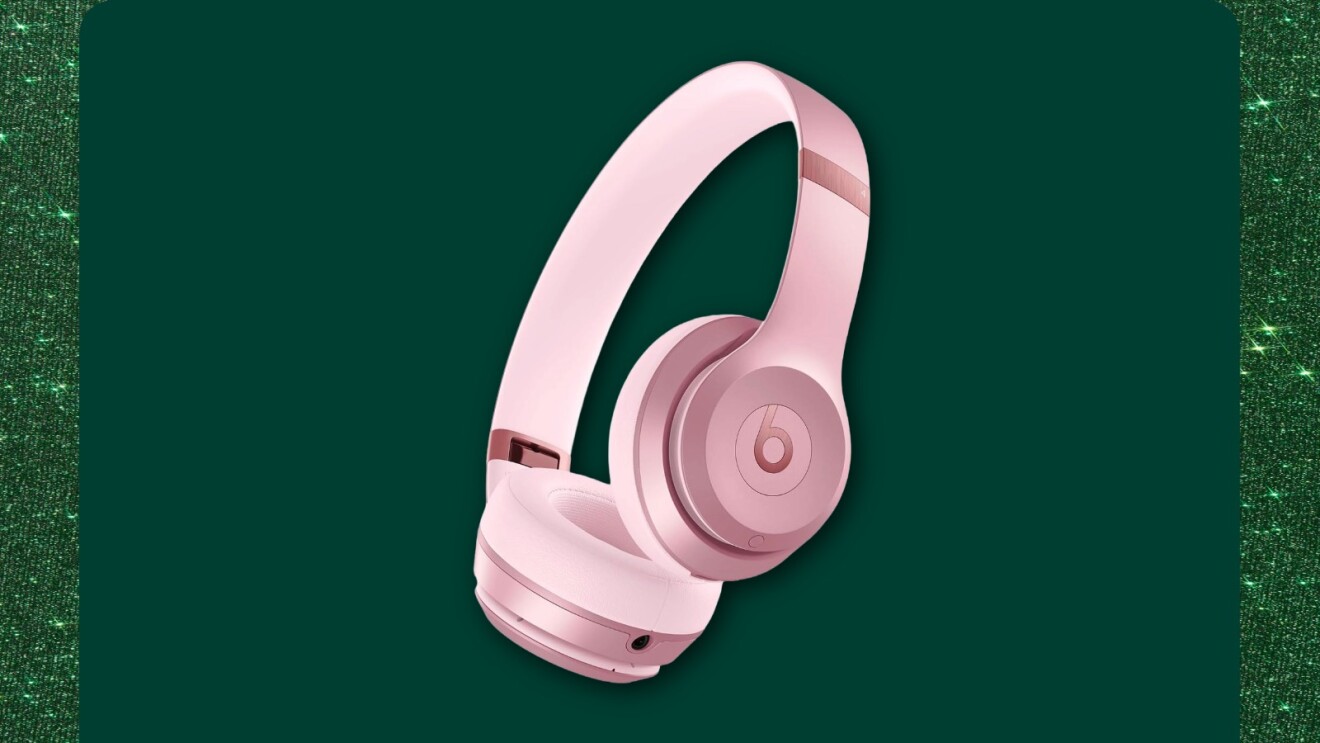 Pink Beats wireless headphones on dark green background