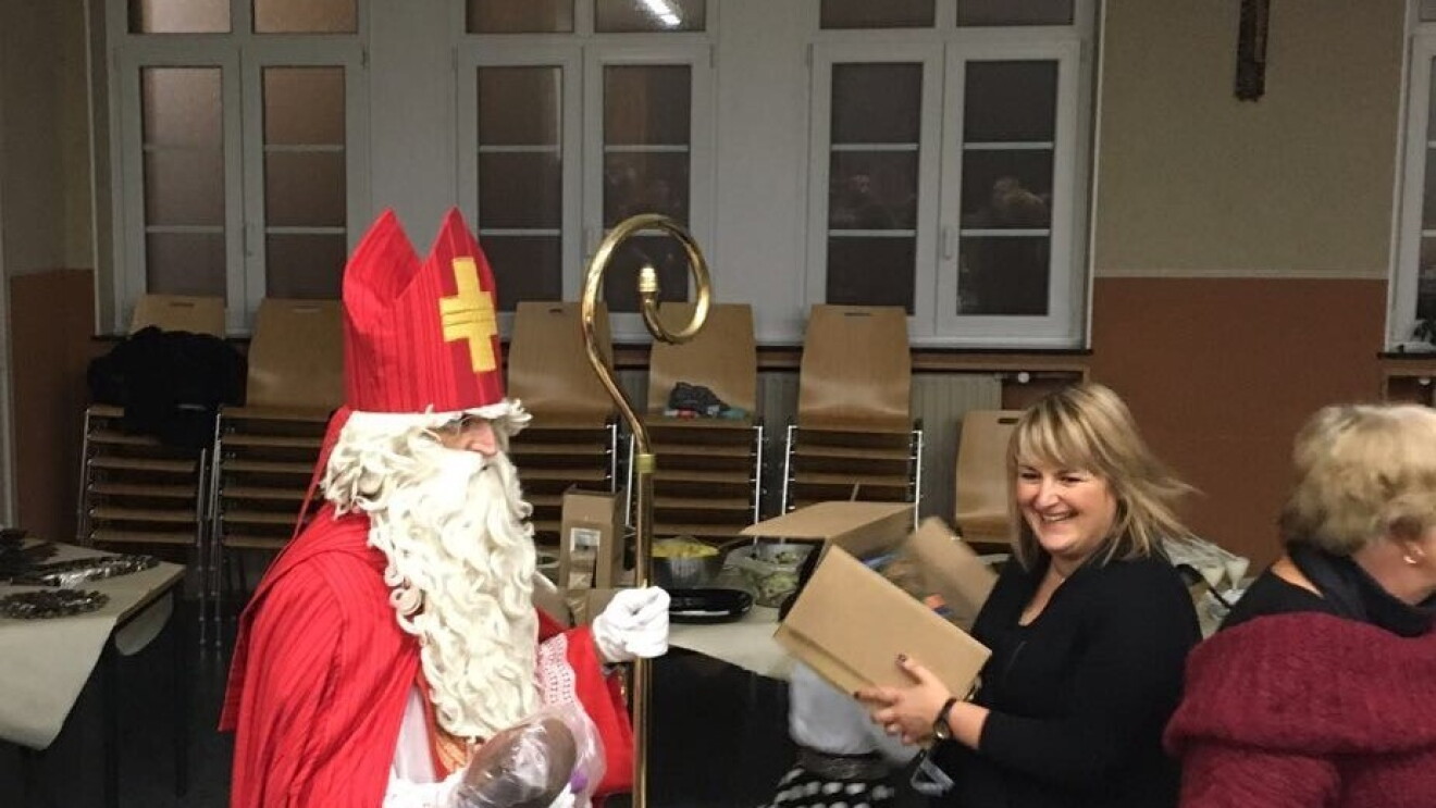 Caritas children celebrating St. Nicholas day with Santa, who delivers gifts to them from Amazon. 