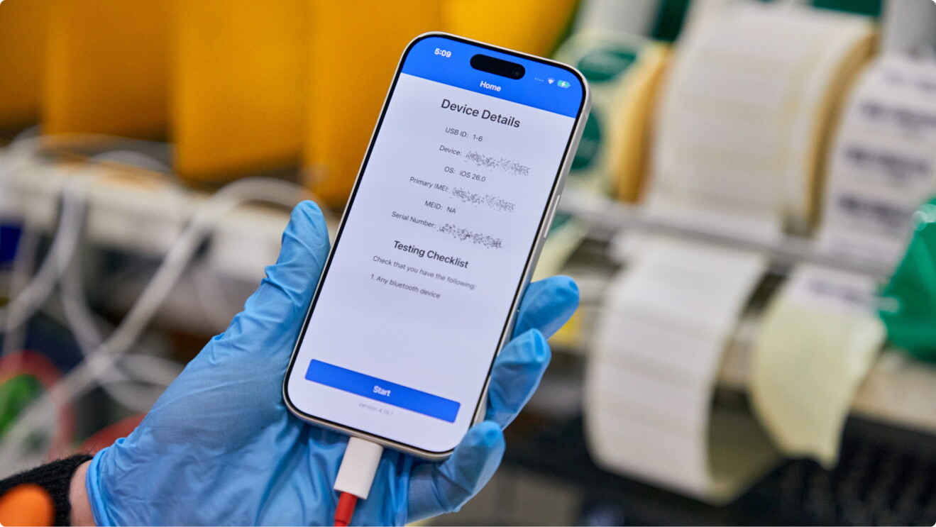 Gloved hands holding smartphone displaying device testing checklist