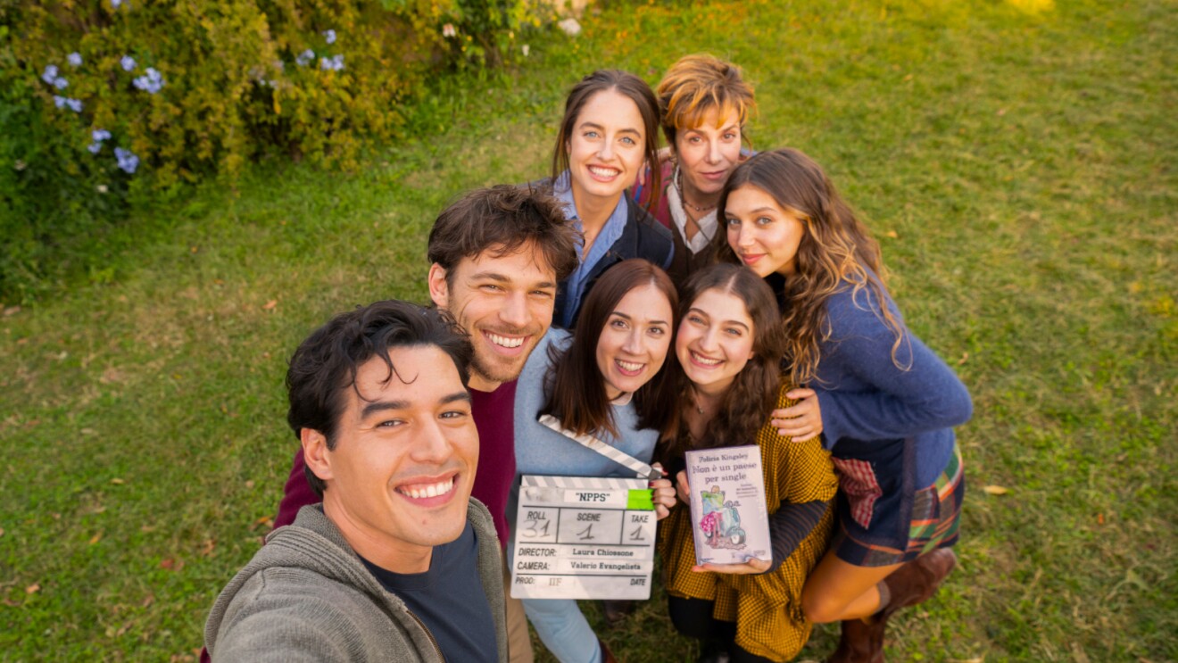 Cast of No Place To Be Single holding the original book and a clapperboard