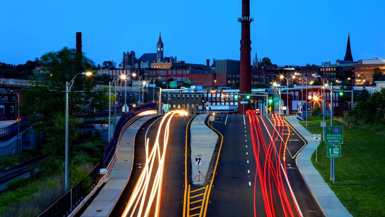 晚上市中心落河,马萨诸塞州,镇上的烟囱,教堂,和条纹在高速公路上的交通,城市天际线。