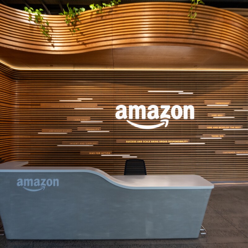 Modern Amazon office reception with curved wooden wall and illuminated logo