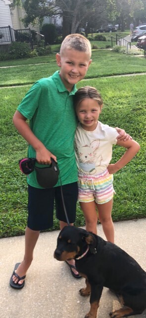 An image of two children smiling for a photo outside.