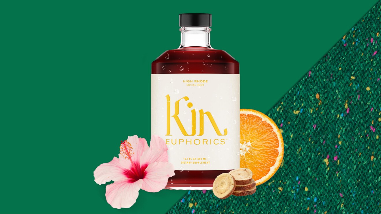 Kin Euphorics bottle with orange slice, hibiscus flower, and ginger on green background