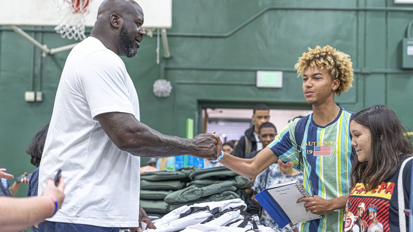 沙奎尔·奥尼尔遇见一个年轻的学生在学校捐赠活动