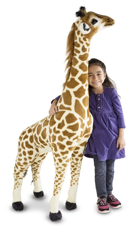 Ein Mädchen kuschelt mit der Melissa Doug Plüschgiraffe, erhältlich auf Amazon.de.
