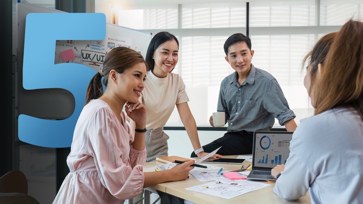 People gathering around a laptop doing work
