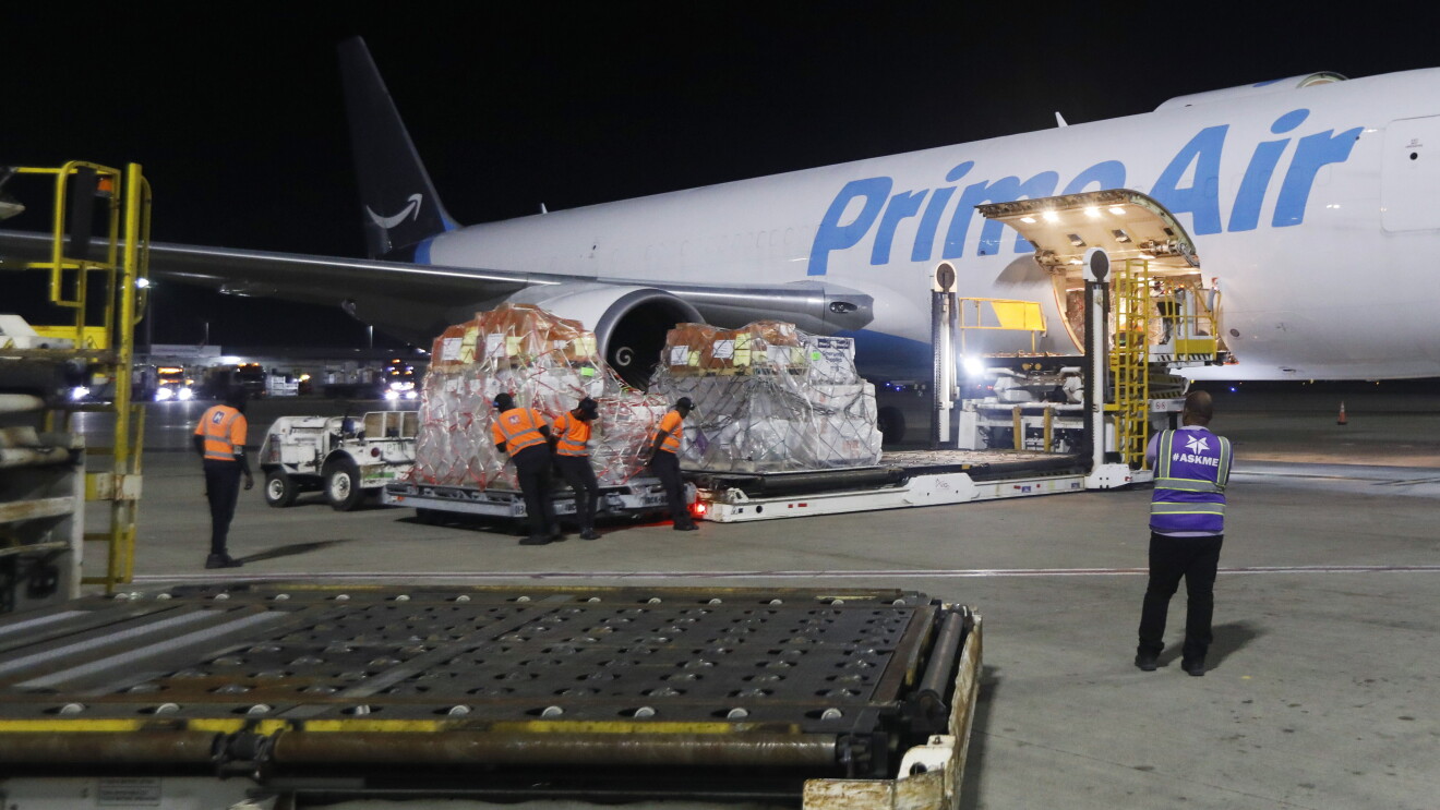 Cargo being loaded onto Prime Air plane at night
