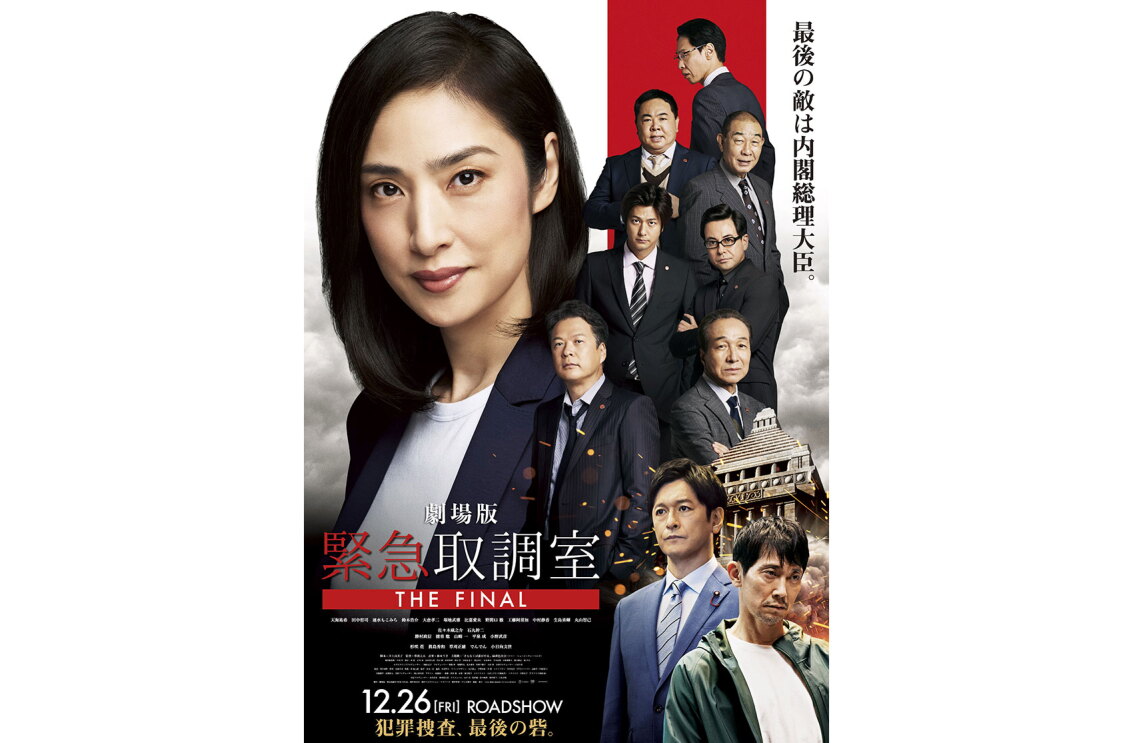 左に大きく配置された黒髪の女性と、右側に小さく並ぶスーツ姿の9人の男性たち。背景に国会議事堂が見える