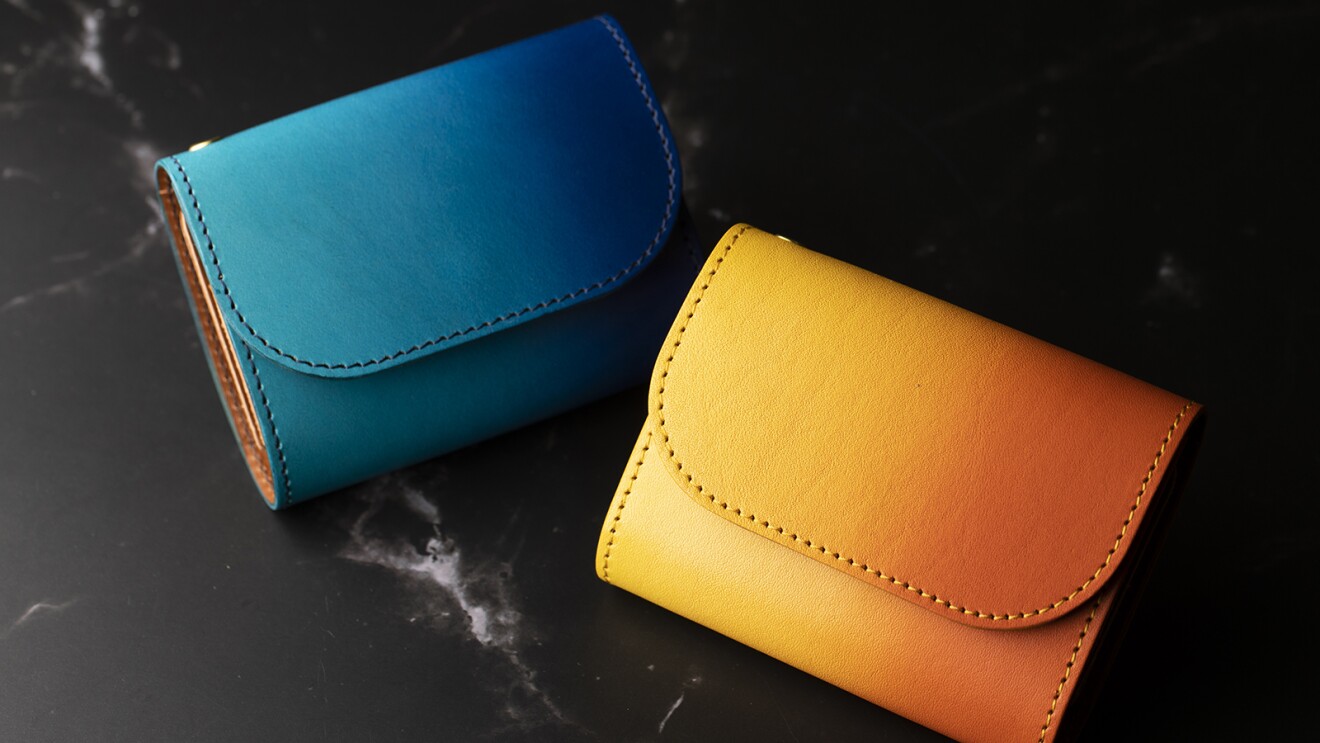 空色と山吹色のぼかし染め財布の写真。明るい色から濃い色へ美しいグラデーションで染められている。