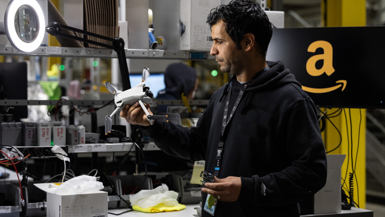 An Amazon fulfillment center worker inspecting a returned drone
