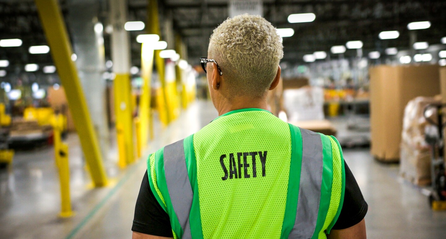 Ein Mitarbeiter mit Sicherheitsweste im Logistikzentrum