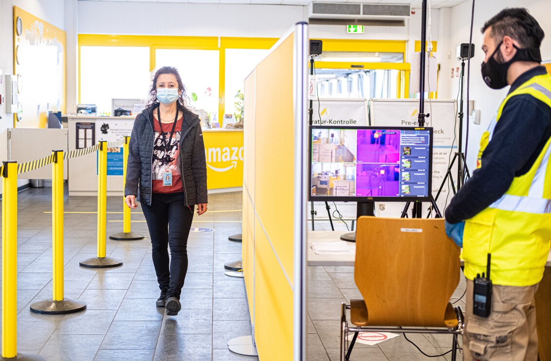 Eine Mitarbeiterin betritt das Logistikzentrum. Dabei wird kontaktlos Fieber gemessen