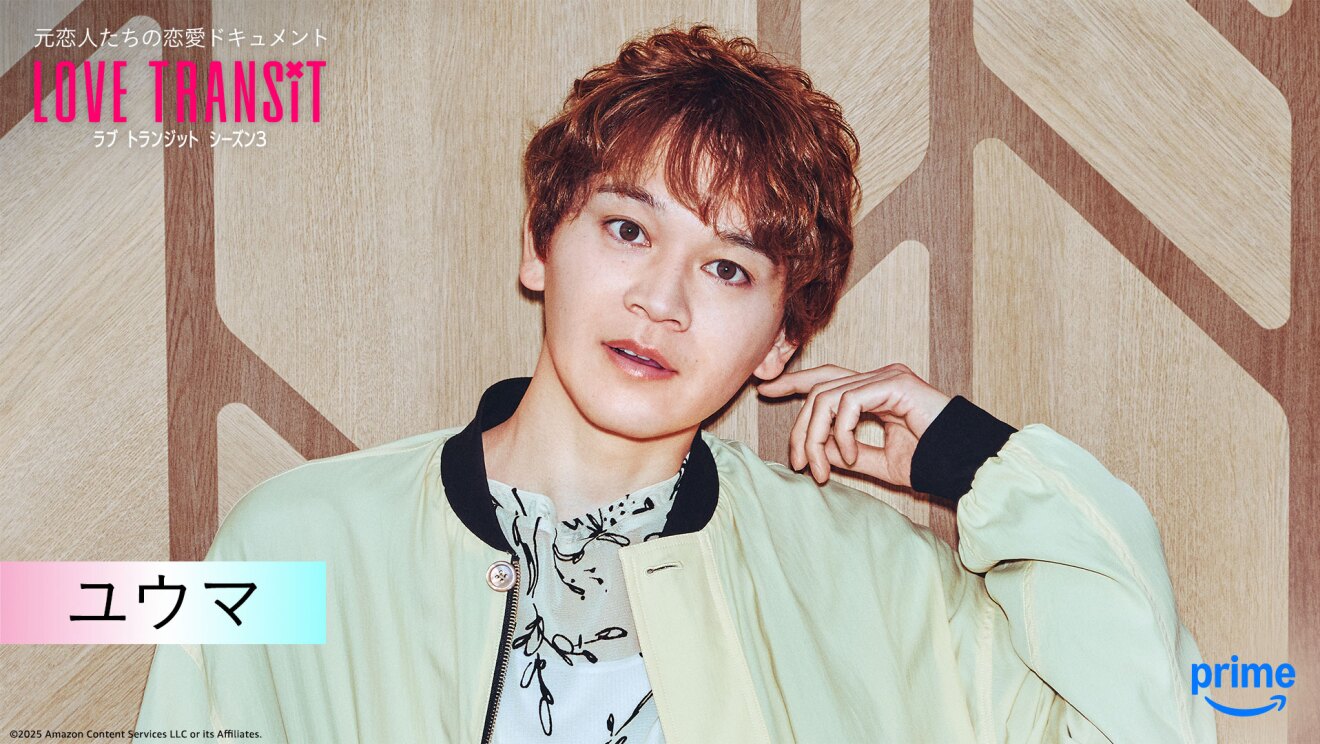 木目調の壁の前に立つ人物のバストアップ。薄い黄緑の上着を着用。左手の人差し指を左耳に当てている。左上隅に「LOVE TRANSIT」の文字。左下に「ユウマ」と名前が表示されている。