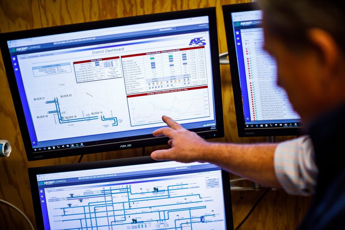 A man points to a computer screen with blueprints on it.