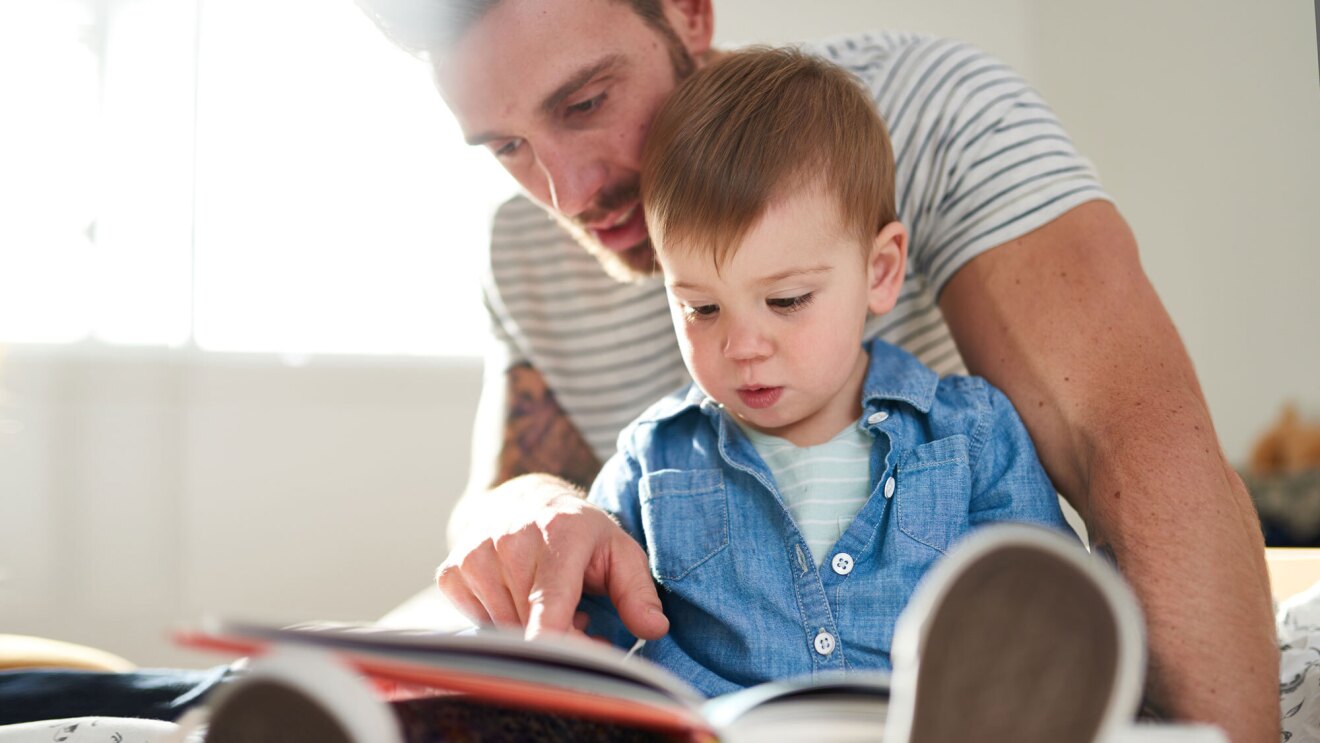 父亲和蹒跚学步的儿子一起读书。